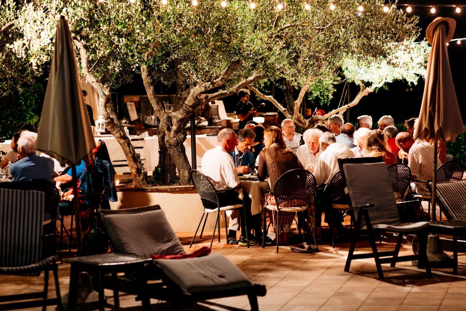 Participants at Cortona Week talking together around a long table in the evening.