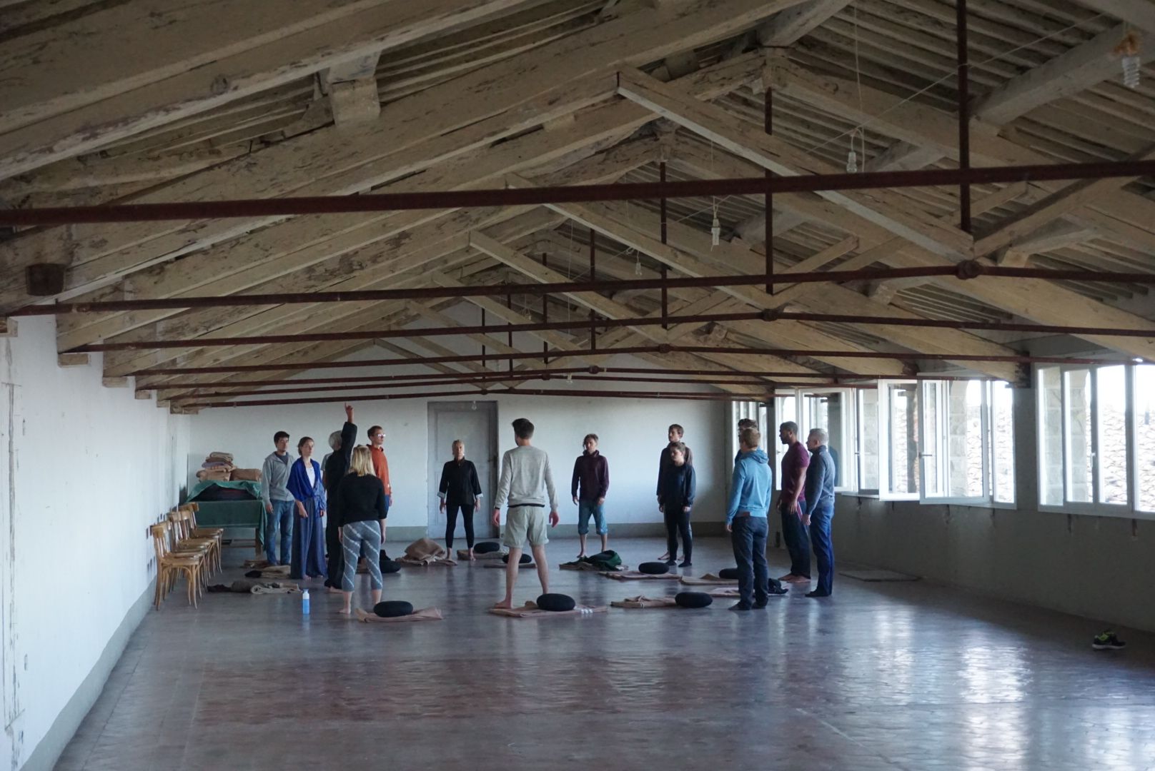 Participants explore movement and attention in a large workshop hall.