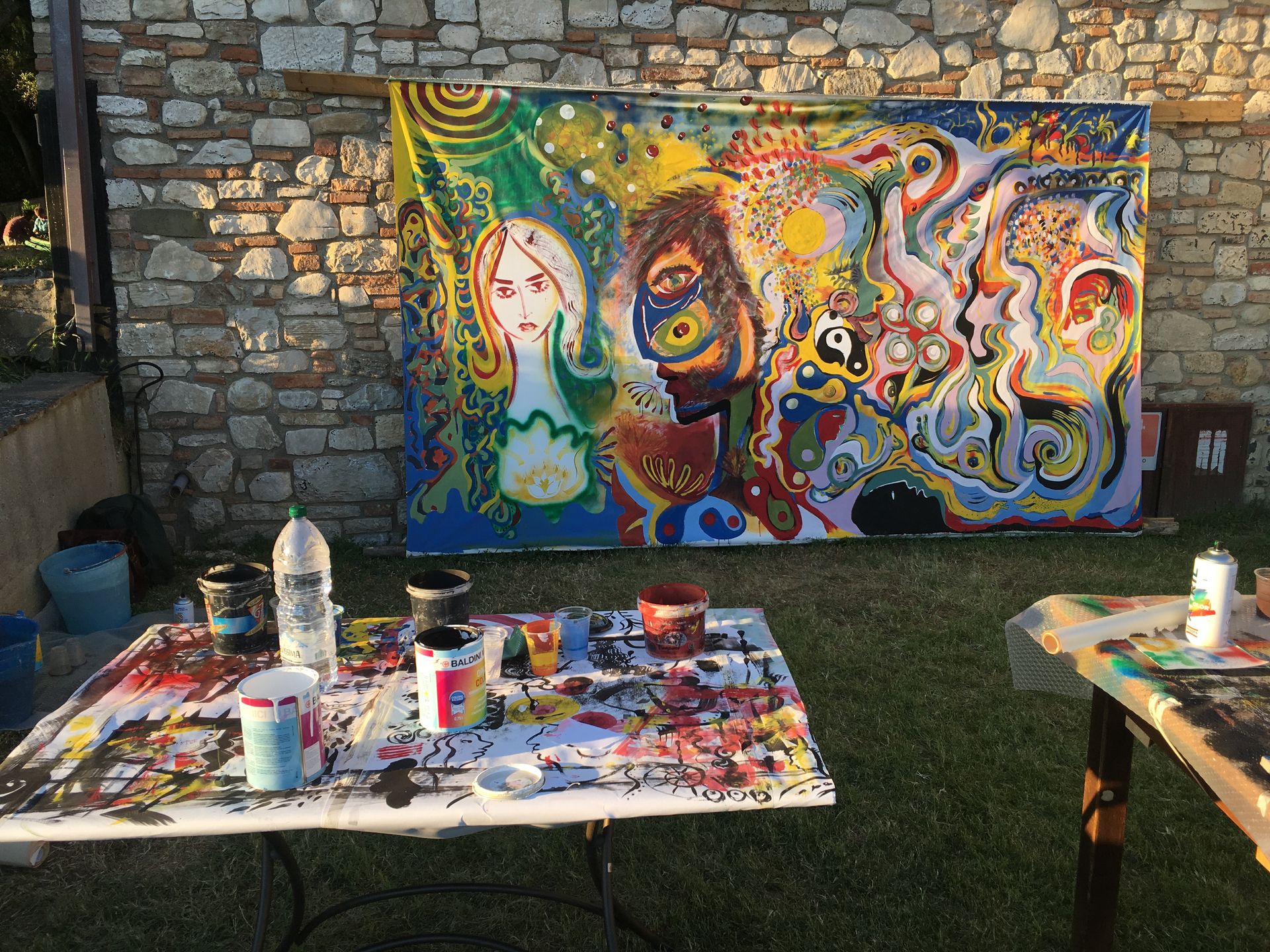 Participants paint together on a large shared canvas during a collective painting workshop.